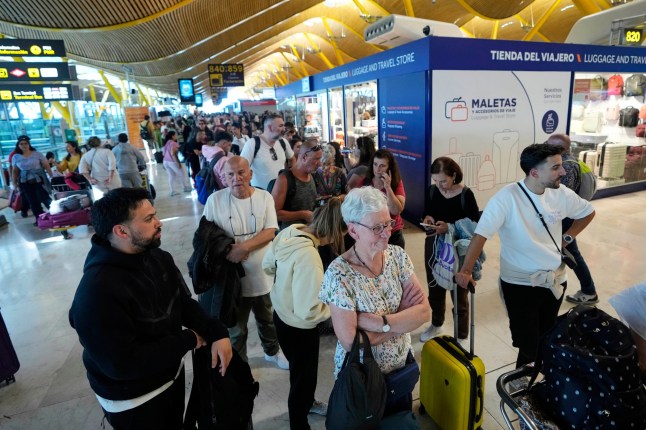 Passengers queue inside Madrid airport, during a nationwide power outage