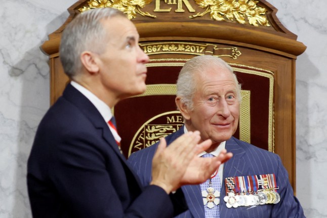Canada's Prime Minister Mark Carney claps after Britain's King Charles III delivered the Speech from the Throne during the opening the first session of the 45th Parliament of Canada at the Senate of Canada in Ottawa on May 27, 2025. Britain's King Charles III is heading to Canada for a brief but "impactful" visit, at a time when President Donald Trump is floating the idea of making his northern neighbour the 51st US state. The 76-year-old monarch, who is also Canada's head of state as part of the Commonwealth, has never publicly commented on the ambitions of the US president, a noted admirer of the royal family. (Photo by Blair Gable / POOL / AFP) (Photo by BLAIR GABLE/POOL/AFP via Getty Images)
